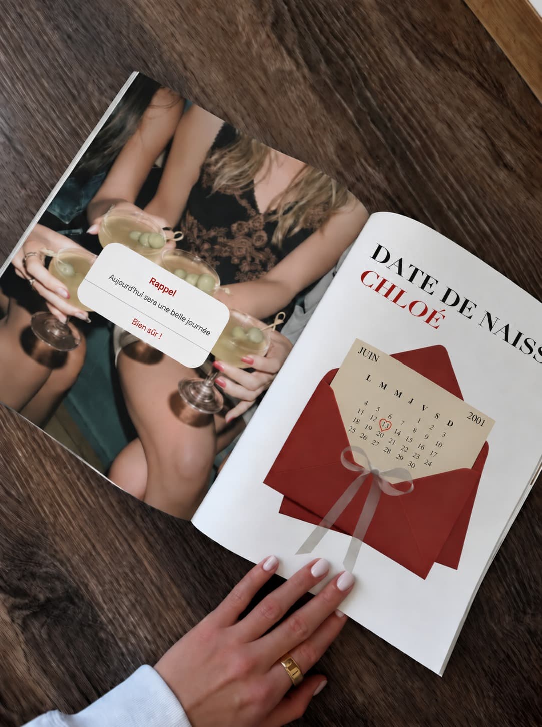 Magazine ouvert tenu à la main sur une table en bois, photo d'amies qui trinquent à gauche, page d'anniversaire avec calendrier à droite